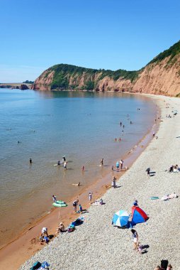 SIDMOUTH, İngiltere - AĞUSTOS 08, 2022 - Jacobs Merdiven plajında arkası kayalıklarla dinlenen turistlerin manzarası, Sidmouth, Devon, İngiltere, Avrupa, 08 Ağustos 2022.