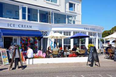 SIDMOUTH, İngiltere - 11 Ağustos 2022 - Fort Cafe 'nin dışında gezinti güvertesi boyunca dinlenen turistler, Sidmouth, Devon, İngiltere, Avrupa, 11 Ağustos 2022.