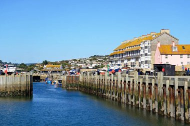 BATI BAY, İngiltere - 10 Ekim 2022 - Limana arka taraftaki iskele kapısı ve kasaba binalarıyla tekne giriyor, West Bay, Dorset, İngiltere, Avrupa, 10 Ekim 2022.