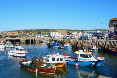 BATI BAY, İngiltere - 10 Ekim 2022 - Limanda demirlemiş balıkçı tekneleri kasaba binaları, Batı Körfezi, Dorset, İngiltere, Avrupa, 10 Ekim 2022.