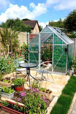 Yeni modern polikarbonat hibrit serası, ön planda masa ve sandalyeler, Chard, Somerset, İngiltere, Avrupa