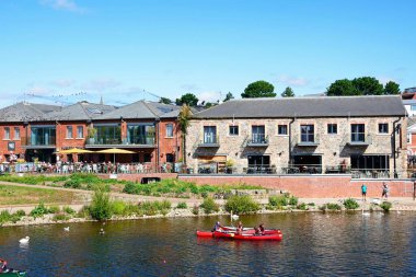 EXETER, UK - 22 AĞUSTOS 2023 - Doğu Rıhtımı boyunca mağazaları ve restoranları bulunan eski nehir boyunca kanocular, Exeter, Devon, İngiltere, Avrupa, 22 Ağustos 2023.