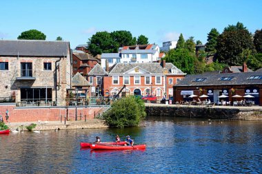 EXETER, UK - 22 AĞUSTOS 2023 - Doğu Rıhtımı boyunca mağazaları ve restoranları bulunan eski nehir boyunca kanocular, Exeter, Devon, İngiltere, Avrupa, 22 Ağustos 2023.
