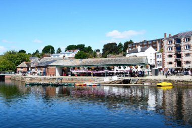 EXETER, UK - 22 AĞUSTOS 2023 - Doğu Rıhtımı boyunca mağazaları ve restoranları bulunan River Exe 'ye demirlemiş sandallar ve pedallar, Exeter, Devon, İngiltere, Avrupa, 22 Ağustos 2023.