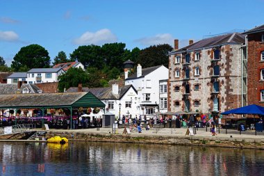 EXETER, UK - 22 AĞUSTOS 2023 - Doğu Rıhtımı boyunca mağazaları ve restoranları bulunan River Exe 'ye demirlemiş sandallar ve pedallar, Exeter, Devon, İngiltere, Avrupa, 22 Ağustos 2023.