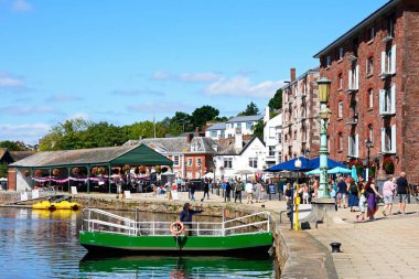 EXETER, UK - 22 AĞUSTOS 2023 - East Bank Quay ile Exe Nehri 'nin karşısındaki kıç feribotu ve sağdaki restoranlar, Exeter, Devon, İngiltere, Avrupa, 22 Ağustos 2023.