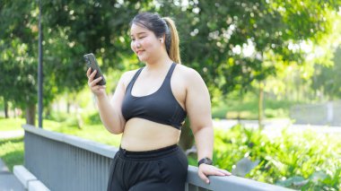  Açık havada akıllı telefon kullanan Asyalı bir kadın.