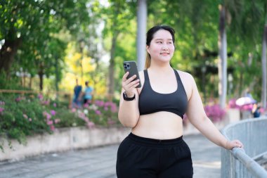  Açık havada akıllı telefon kullanan Asyalı bir kadın.