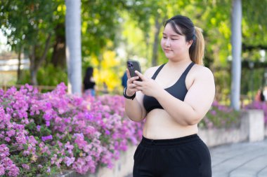  Açık havada akıllı telefon kullanan Asyalı bir kadın.
