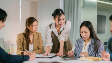 Stratejileri tartışan çeşitli profesyonellerle ortak bir iş toplantısı. Bağlı takım çalışması, odaklı tartışmalar ve dijital araçlar verimliliği artırır. Lider Takım Çalışması