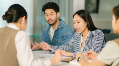 Çeşitli profesyonellerle fikir alışverişinde bulunan bir ortaklaşa iş toplantısı. Bağlı bireyler modern ofis ortamında görüşlerini paylaşıyor, takım çalışmasını teşvik ediyor ve yenilikleri geliştiriyor. Lider Takım Çalışması