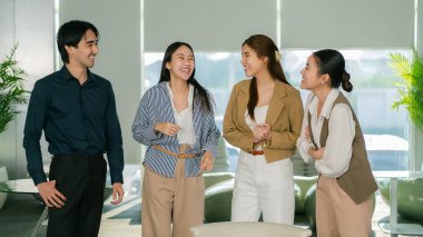 Modern ofis lideri takım çalışmasında gülen ve tartışan bir grup profesyonel.