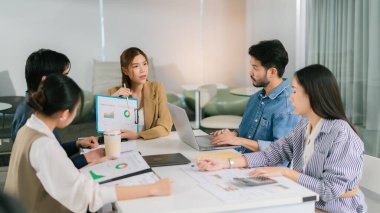 Çeşitli profesyonellerle veri analizi ve stratejileri tartışan ortak bir iş toplantısı. Nişanlı takım üyeleri anlayış ve fikirleri paylaşır. Lider Takım Çalışması