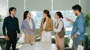 Modern ofis ortamında fikirleri tartışan nişanlı bir iş ekibi. Lider Takım Çalışması