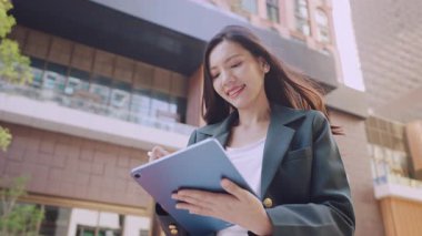 Şehir sokaklarında stilus kalemle tablet bilgisayarda görev yapan iş kadınının portresi 