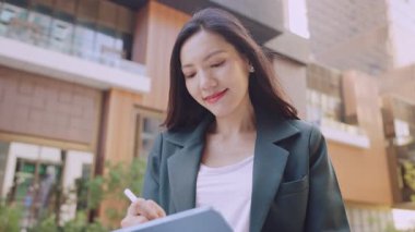 Şehir sokaklarında stilus kalemle tablet bilgisayarda görev yapan iş kadınının portresi 