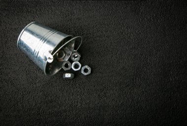 Siyah arka planda fındıklı metal kova, metal bağlayıcılar.