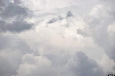 Fotoğraf, yaz yağmurundan önce ağır bulutlarla dolu karanlık bir gökyüzünü gösteriyor. Atmosfer sakin, yaklaşan yağış bekleniyor..