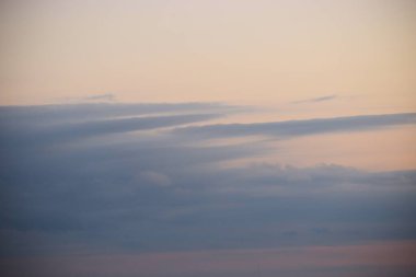 Fotoğraf, bulutlu bir gökyüzü ile denizin üzerinde gün batımını gösteriyor. Sakin bir atmosfer ve sonsuz bir boşluk hissi yaratıyor.