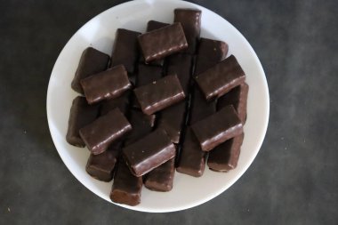 Çeşit çeşit çikolatalı şekerlemeli bir tabağın yakın çekimi, tatlılık ve görsel zevki çağrıştırıyor.