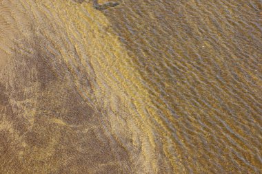 Vistula Nehri 'nin kumlu nehir yatağına yakın çekim, temiz su ortamındaki doğal çökeltileri, dokuları ve sualtı manzarasını gösteriyor..
