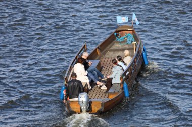 Motorboat moving along the Vistula River, creating waves and capturing dynamic water motion, travel, leisure, and river scenery in a natural landscape.