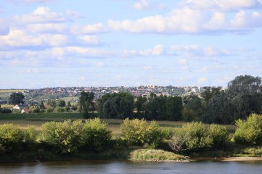 Vistula Nehri üzerindeki bir köprüden Swiecie şehrinin panoramik manzarası, şehir manzarası, nehir manzarası, mimari ve çevre yeşillikleri vurguluyor..