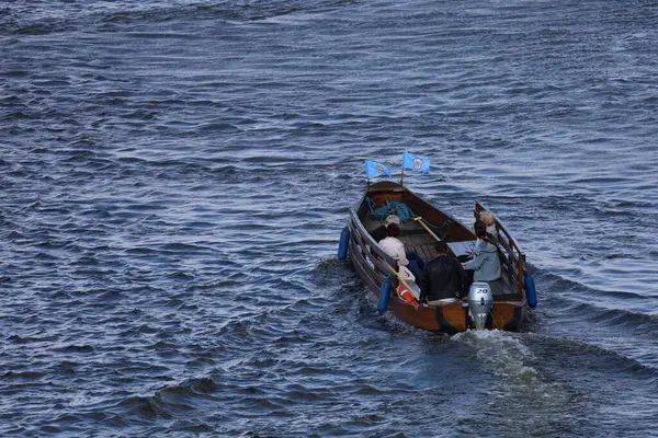 Motorboat moving along the Vistula River, creating waves and capturing dynamic water motion, travel, leisure, and river scenery in a natural landscape.