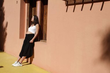 Hamile kadınlar evinin duvarında güneşleniyorlar.