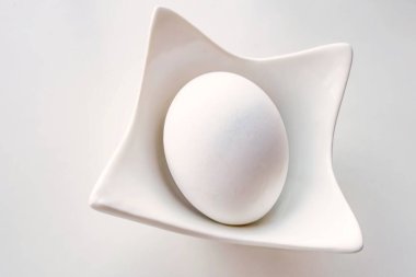 Dekoratif küçük kasede haşlanmış tavuk yumurtası.