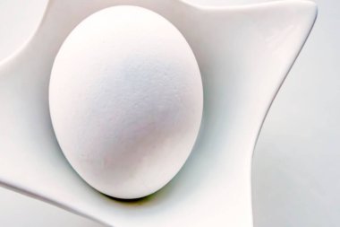 Dekoratif küçük kasede haşlanmış tavuk yumurtası.