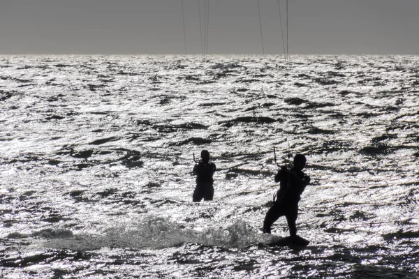 海の上でカイトサーフィンする人々のシルエットは — ストック写真