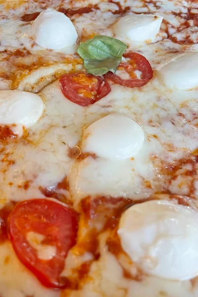 Pizza Margherita , a typical Neapolitan pizza, made with San Marzano tomatoes, mozzarella cheese, fresh basil, salt, and extra-virgin olive oil.