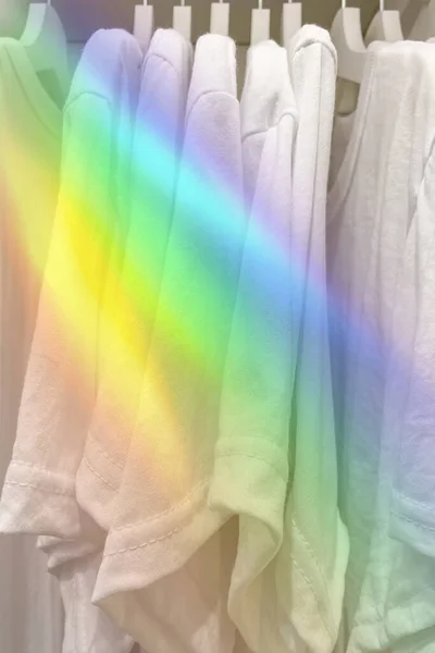 白色T恤衫挂在有彩虹效果的衣柜里 — 图库照片