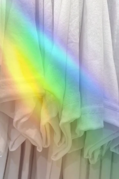 白色T恤衫挂在有彩虹效果的衣柜里 — 图库照片