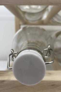 bottles with caps on wooden shelf