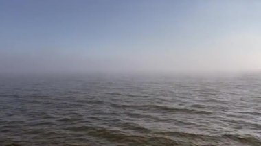 Sisli kıyı şeridi, dalgalı akıntılar. Sisli deniz, dalgalı gelgitler.