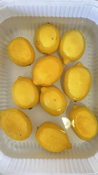 澄んだ水に閉じ込められた黄色のレモン — ストック写真