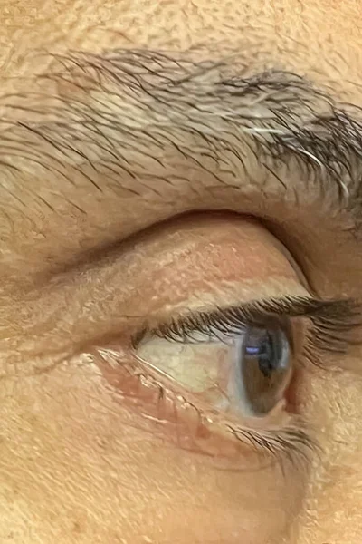 肌にしわを持つ男の目のクローズアップ — ストックベクタ