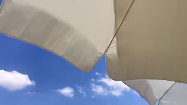 Голубое Небо Пляжный Зонтик Жаркий Ветреный Летний День Море Пляж — стоковое видео