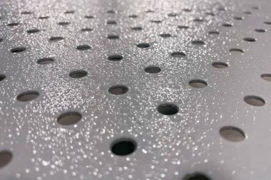 Gri yüzey. Yuvarlak delikli çelik plaka. Yakın çekim..