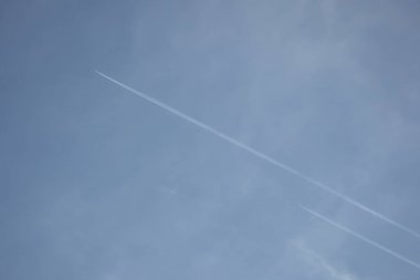 Hafif bulutlu bir sonbahar günü. Mavi gökyüzü ve uçak izleri. Buhar izi..