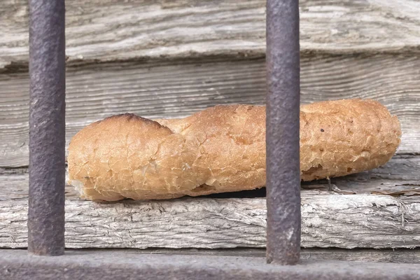 Dried stale bread behind rusty iron bars. Outdoor.