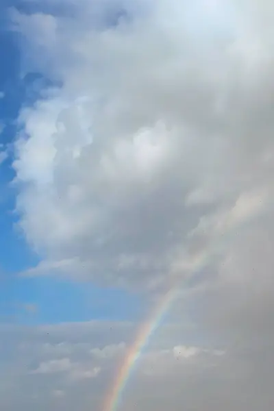 Blue sky with few clouds. rainbow after rain.