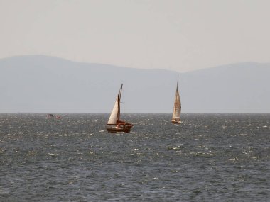 İstanbul, Türkiye. 17 Ağustos 2024 Fenerbahçe Shore 'da yelkenliler. Bu puslu ve sisli Ağustos gününde, Istanbuls Fenerbahçe kıyı şeridi açıklarındaki Marmara Denizi' nin parıldayan sularında yelkenliler süzülüyor. Marmara denizi. İstanbul İli.