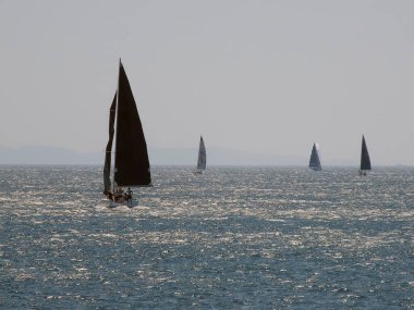 İstanbul, Türkiye. 17 Ağustos 2024 Fenerbahçe Shore 'da yelkenliler. Bu puslu ve sisli Ağustos gününde, Istanbuls Fenerbahçe kıyı şeridi açıklarındaki Marmara Denizi' nin parıldayan sularında yelkenliler süzülüyor. Marmara denizi. İstanbul İli.