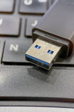 USB 3.0 Flaş bellek. Yakın plan. Bir USB 3.0 flash diskin metal konnektörü ve siyah kutu detayları. Bu resim veri transferi, taşınabilir depolama çözümleri ve modern teknoloji kavramlarını açıklamak için mükemmeldir..