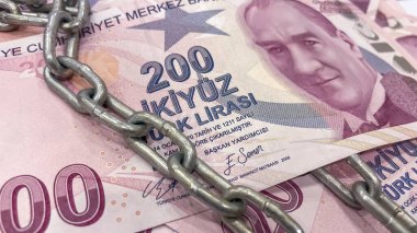 Türk Lirası 'nın güvenliği. 200 TL' lik banknotlar zincirli. 200 TL 'lik Türk Lirası banknotlar. Metal bir zincir ile bağlanmış. Finansal güvenlik, ekonomik kısıtlamalar ve para politikalarıyla ilgili konular için ideal bir temsil görevi görmektedir.. 