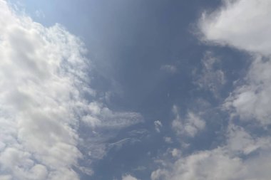 Soğutucu Bulutların Altında. Yazın sıcak günlerinde huzur veren dans eden beyaz bulutlarla dolu derin mavi bir gökyüzü. Doğa fotoğrafçılığı ve seyahat blogları için ideal.