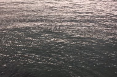 Sakin, dalgalı bir su yüzeyi. Sakin bir su yüzeyinin huzurlu bir görüntüsü. Doğal ve minimalist bir atmosfer yaratmak için ideal. Sakin bir su yüzeyinin yansımalarından oluşan büyüleyici bir görüntü..